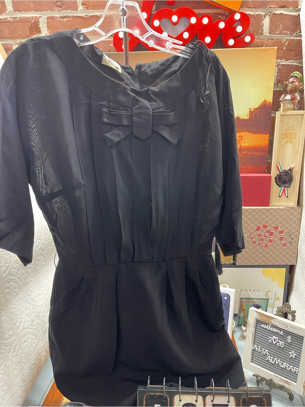 Vtg elegant black dress features a charming front bow accent and delicate pleate